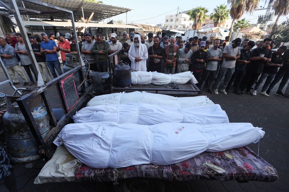 u200bMourners pray near the bodies of Palestinians, who were killed in an Israeli strike