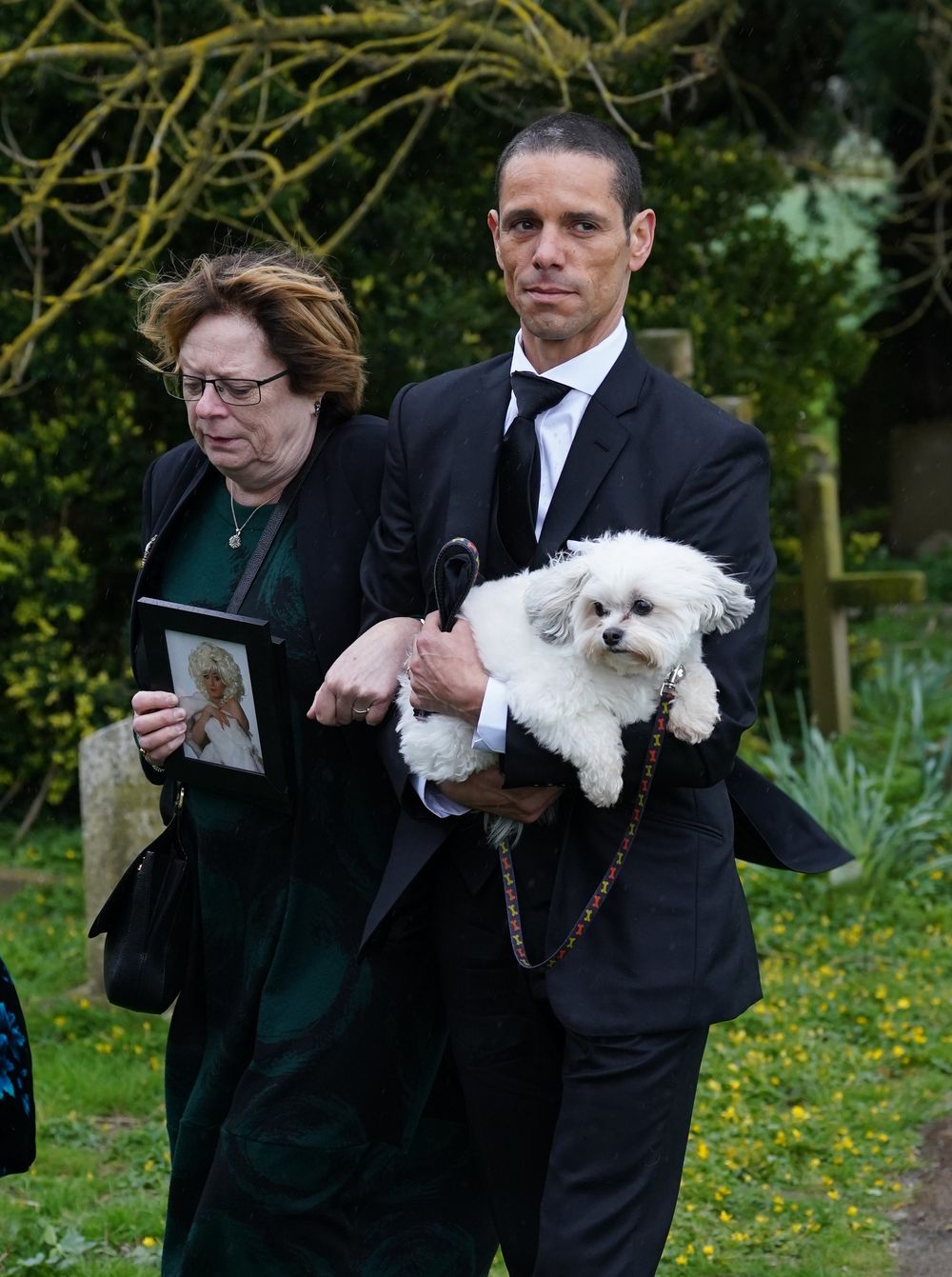 \u200bO'Grady's husband Andre Portasio attending the star's funeral with one of their dogs