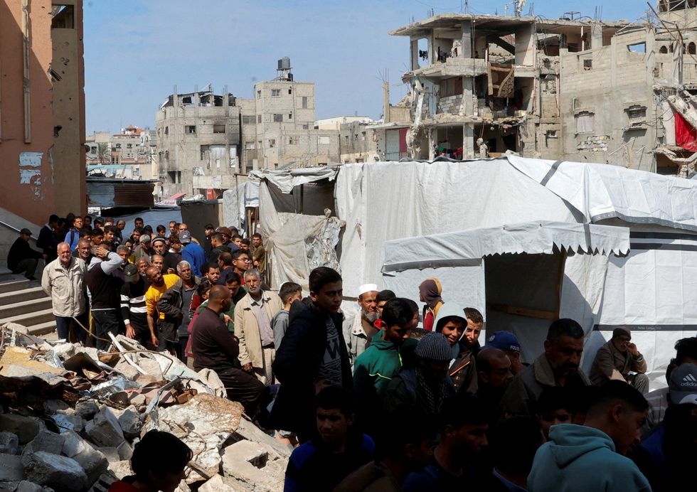 u200bPalestinians gather to receive bread from a bakery, in Khan Younis