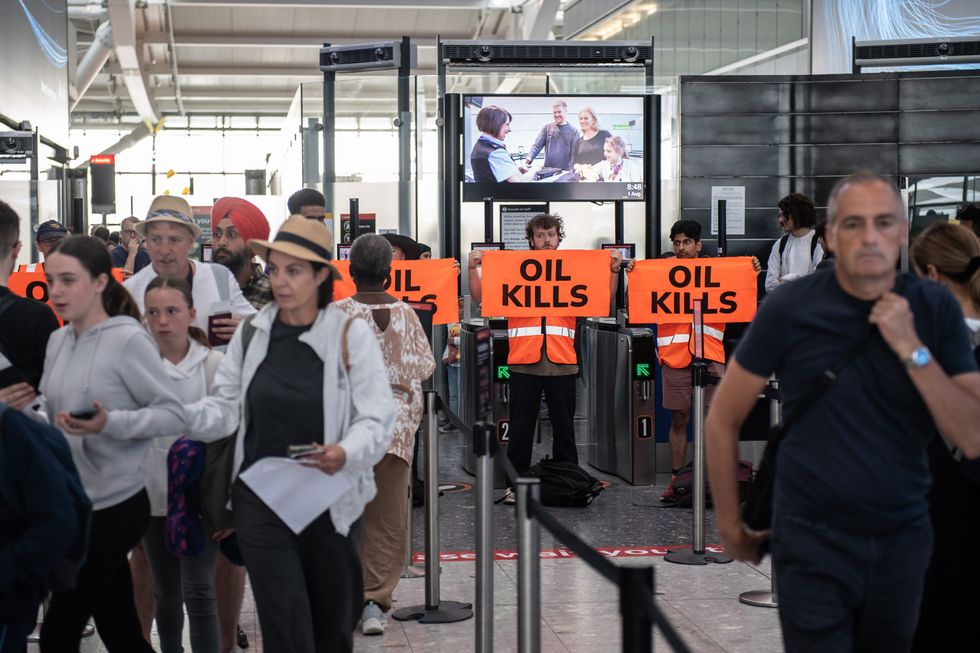 \u200bPassengers move to a different departure gate as Just Stop Oil protestors block the departure gates at Heathrow Terminal 5