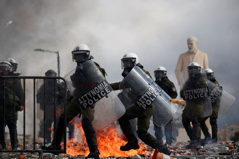 \u200bPolice holds shields during clashes near the Greek parliament at a protest