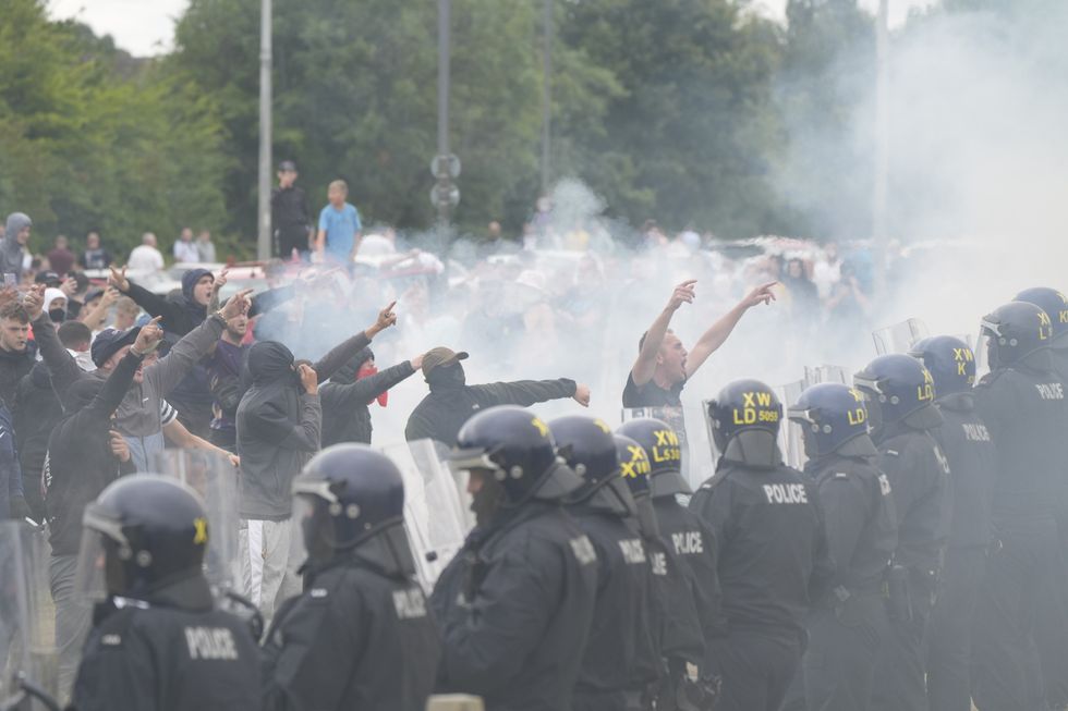 u200bPolice officers face protesters during an anti-immigration demonstration outside the Holiday Inn Express in Rotherham