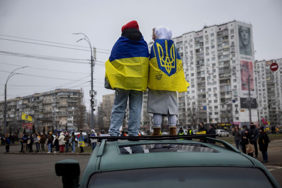 \u200bUkrainian flags are draped over the shoulders of protesters during a rally calling for the release of Ukrainian prisoners of war