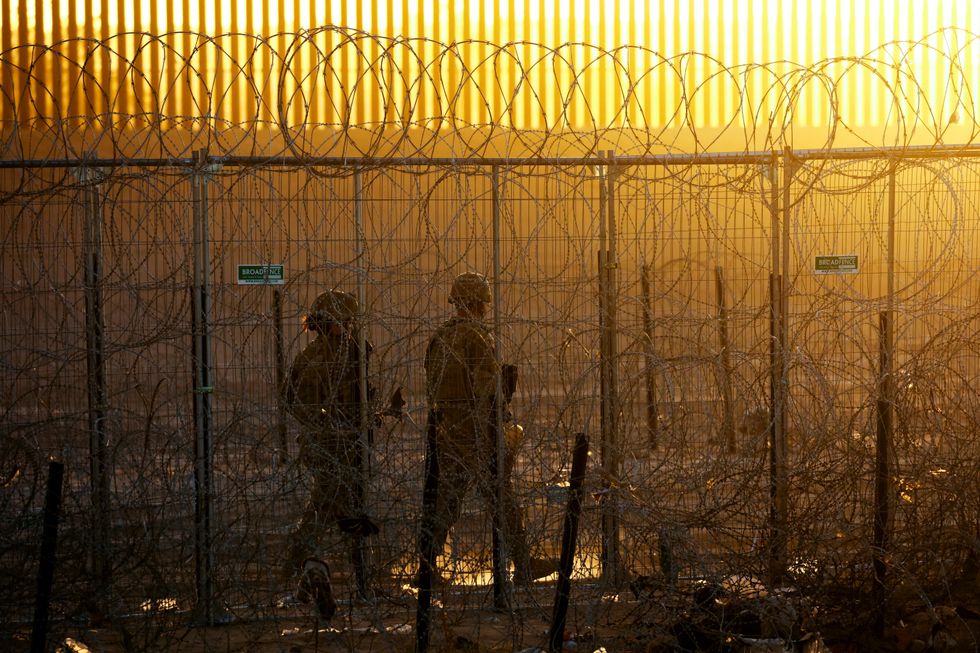 \u200bUS Border Force officers walk past fence