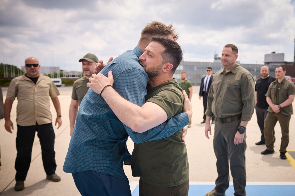 Ukraine's President Volodymyr Zelenskiy embraces one of commanders