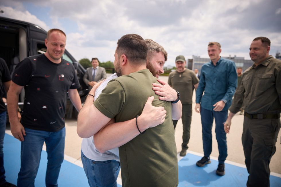 Ukraine's President Volodymyr Zelenskiy embraces one of commanders