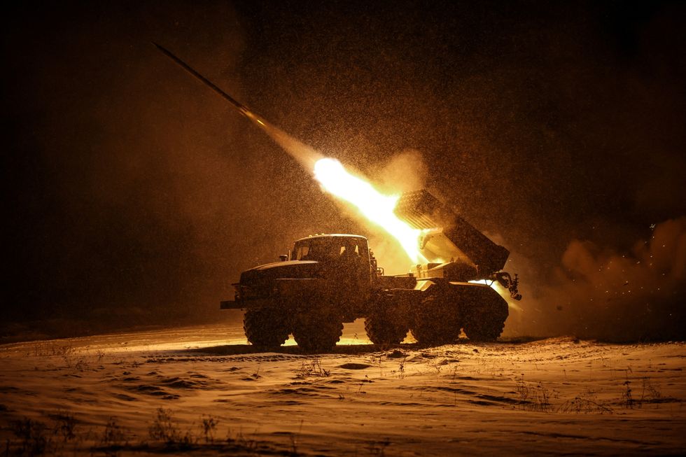 Ukrainian forces fire a BM-21 Grad multiple-launch rocket system toward Russian troops on the front line