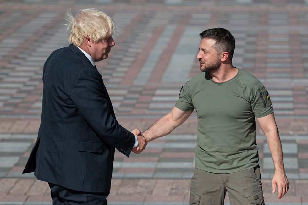 Ukrainian President Volodymyr Zelensky shakes hands with former British Prime Minister Boris Johnson