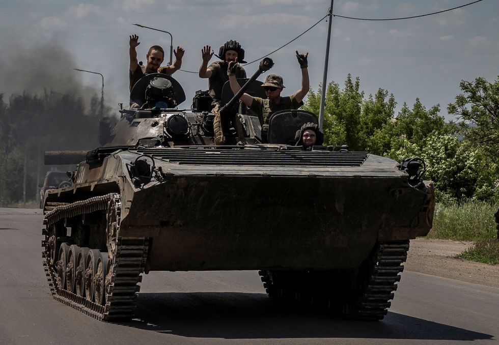 Ukrainian service members ride a BMP-1 infantry fighting vehicle