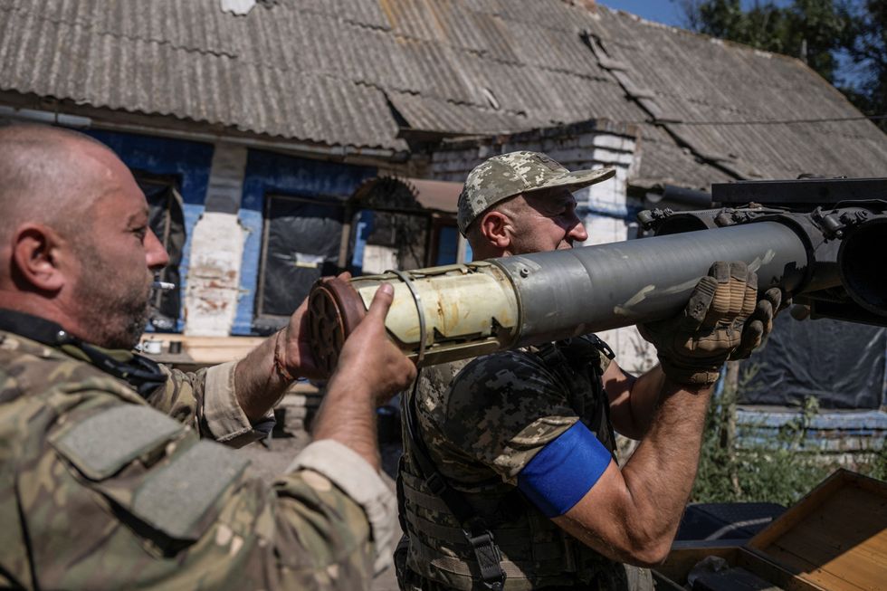 Ukrainian servicemen of the 108th Separate Brigade of Territorial Defence load a shell into a small multiple launch rocket systems before firing toward Russian troops