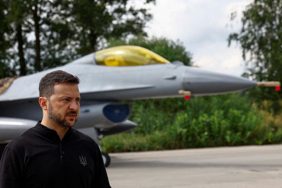 Volodymyr Zelensky speaks to the media in a front of an F16 fighting aircraft after marking the Day of the Ukrainian Air Forces