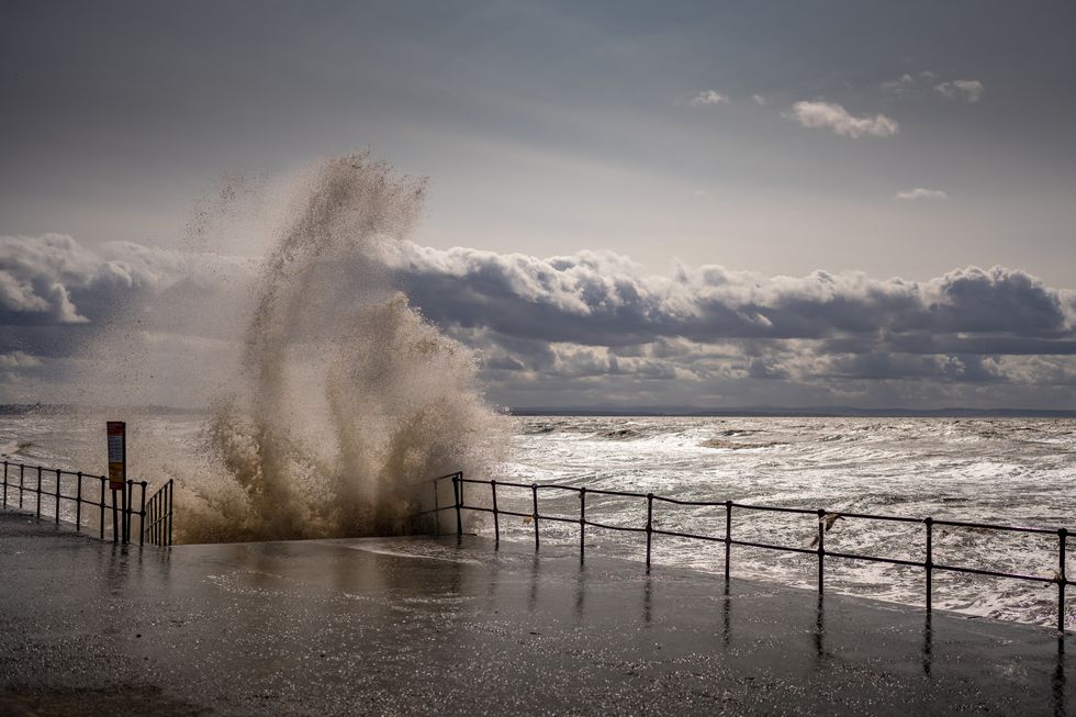 Waves whipped up by the wind hit Crosby Beach promenade as Storm Lilian brings rain and high winds to the UK