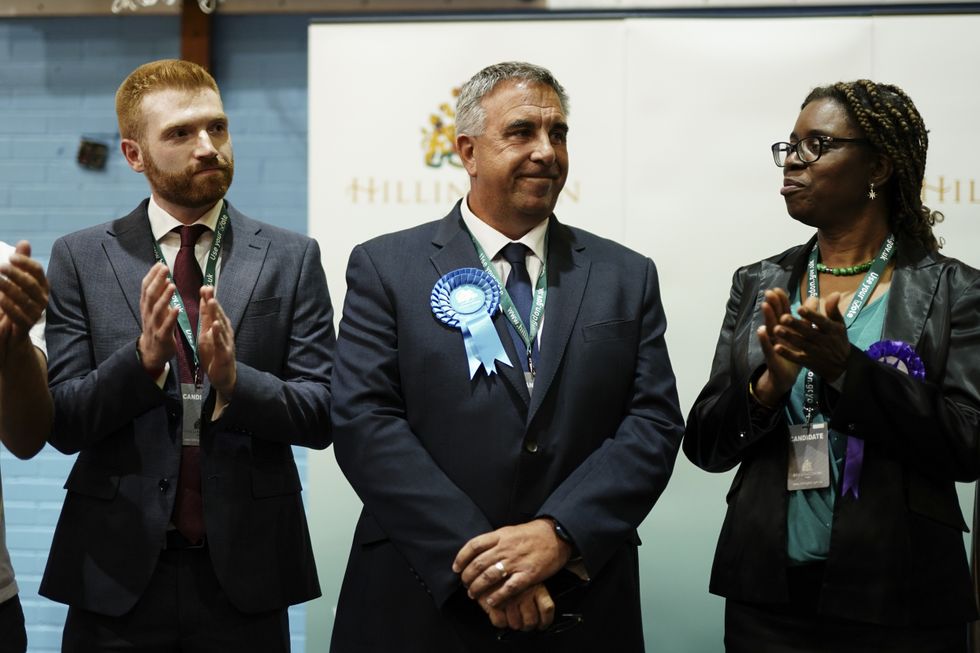 Winning Conservative candidate Steve Tuckwell with Labour candidate Danny Beales (left) at Queensmead Sports Centre in South Ruislip