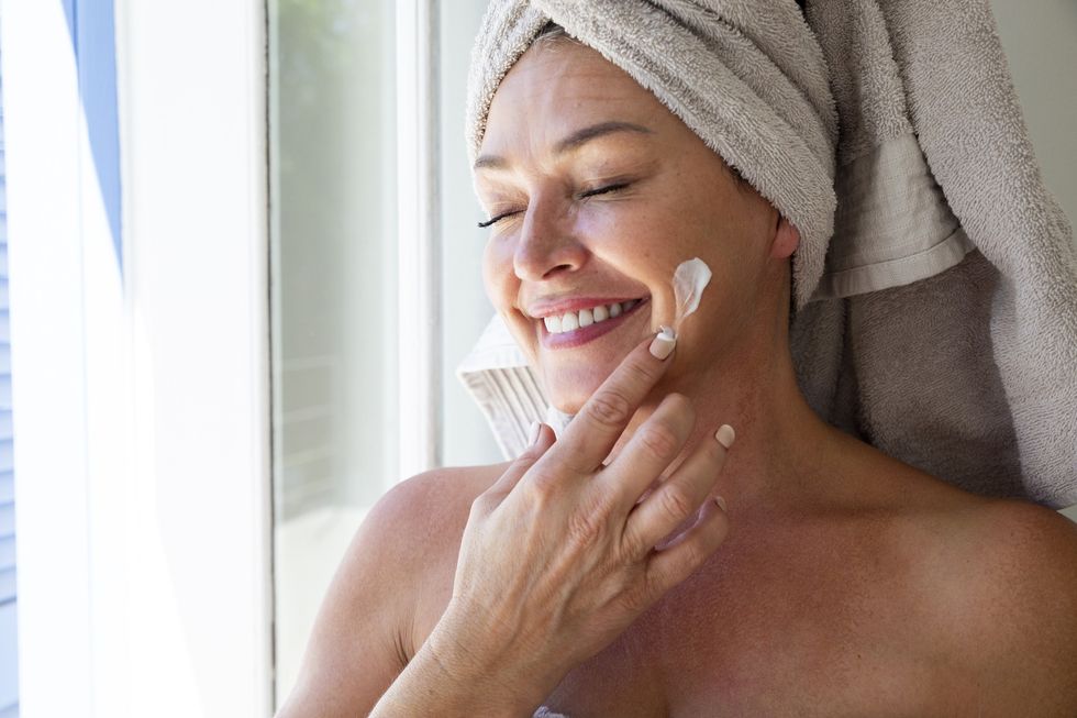 Woman applying moisturiser