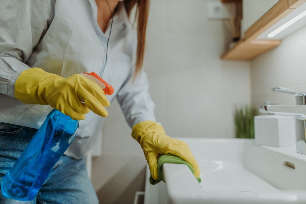 Woman cleaning bathroom sink