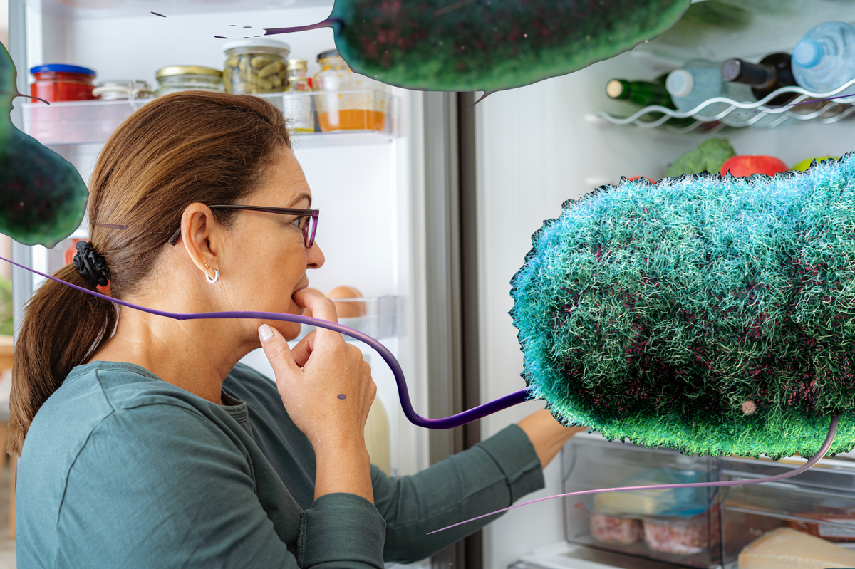 Woman inspecting her fridge covered in E.coli 