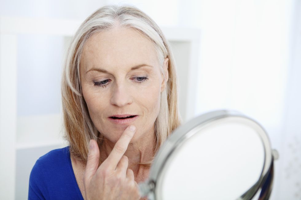 Woman looking at face in mirror