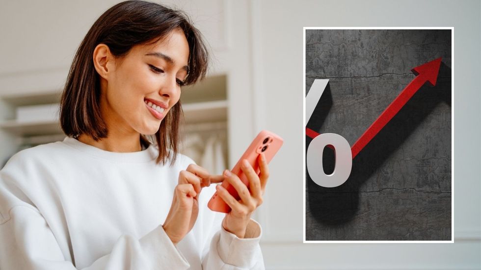 Woman looking at phone and interest rate rise