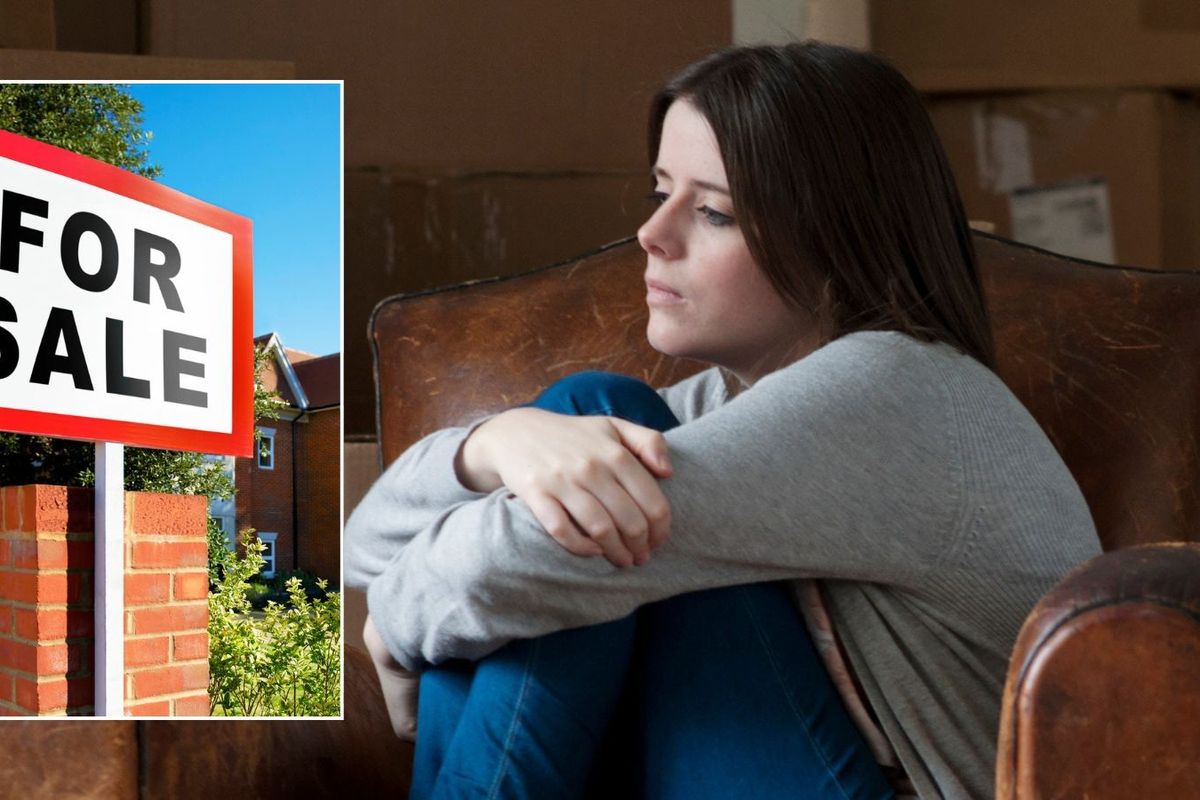 Woman looking worried and for sale sign outside house 