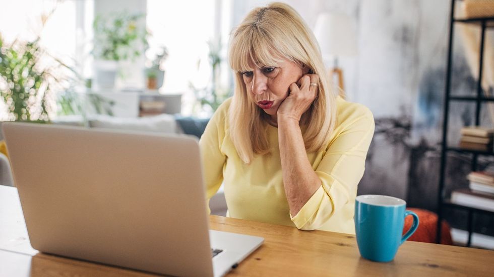 Woman looks worried at laptop