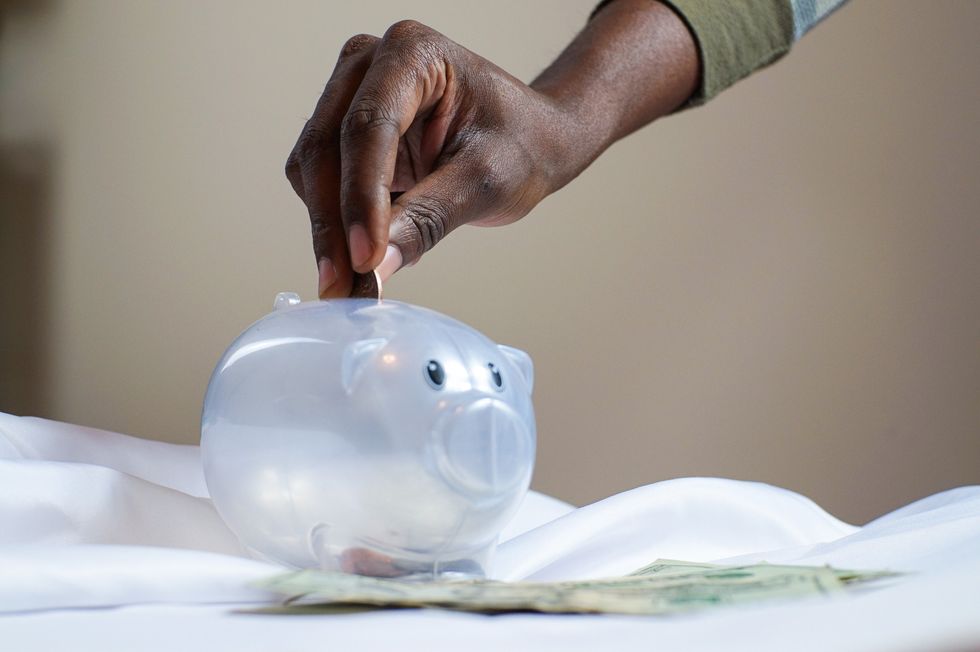 Woman putting money in a piggy bank