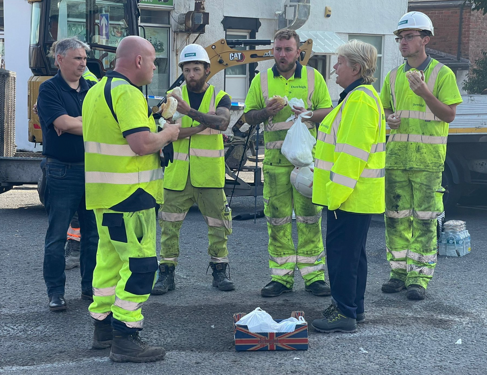 Workers eat sandwiches amid clean-up efforts